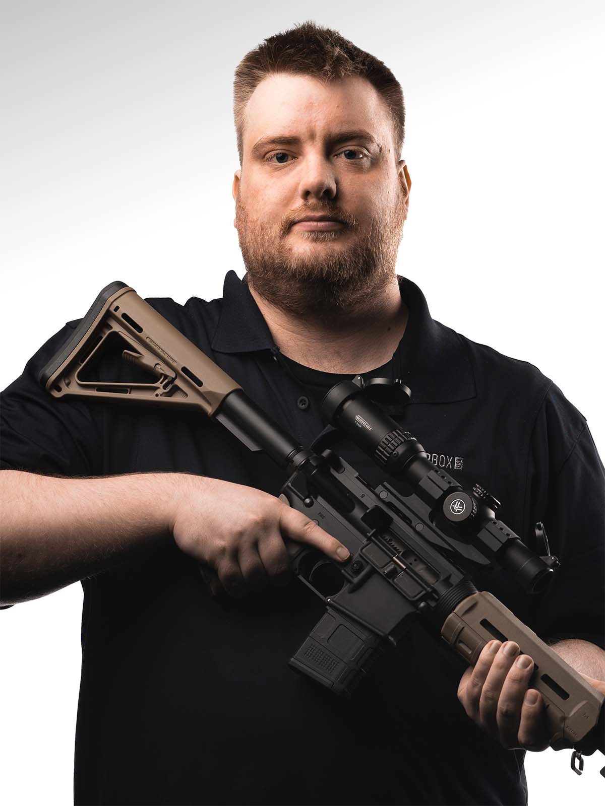 Person holding a rifle against a white background.