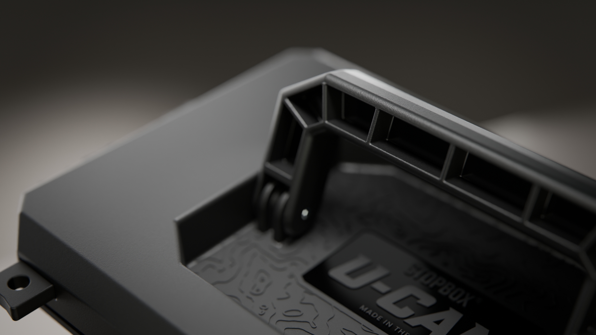 A close-up shot of the handle and textured lid of a rugged, matte black case.