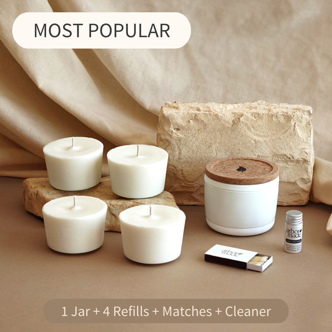 Four white candles, a jar, matches, and cleaner on a beige background.