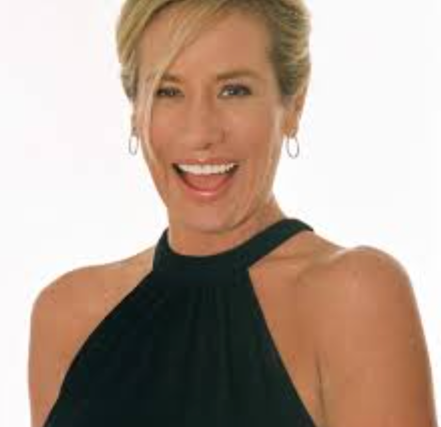 Headshot of a smiling woman with short blonde hair, wearing a black halter top against a white background.