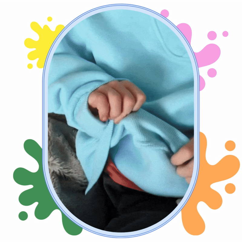 Child's hand pulling a blue sweater sleeve, colorful splashes in the background.