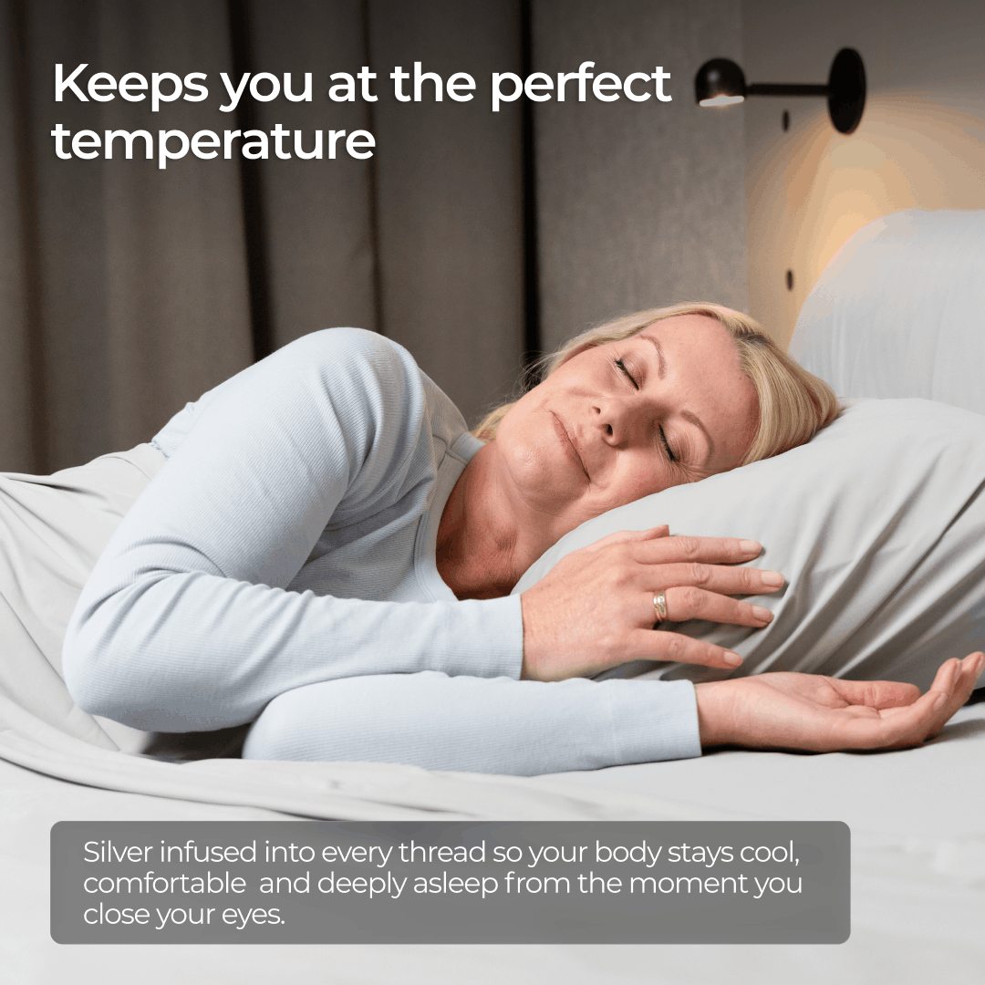 A blonde woman sleeping peacefully in bed with grey sheets.