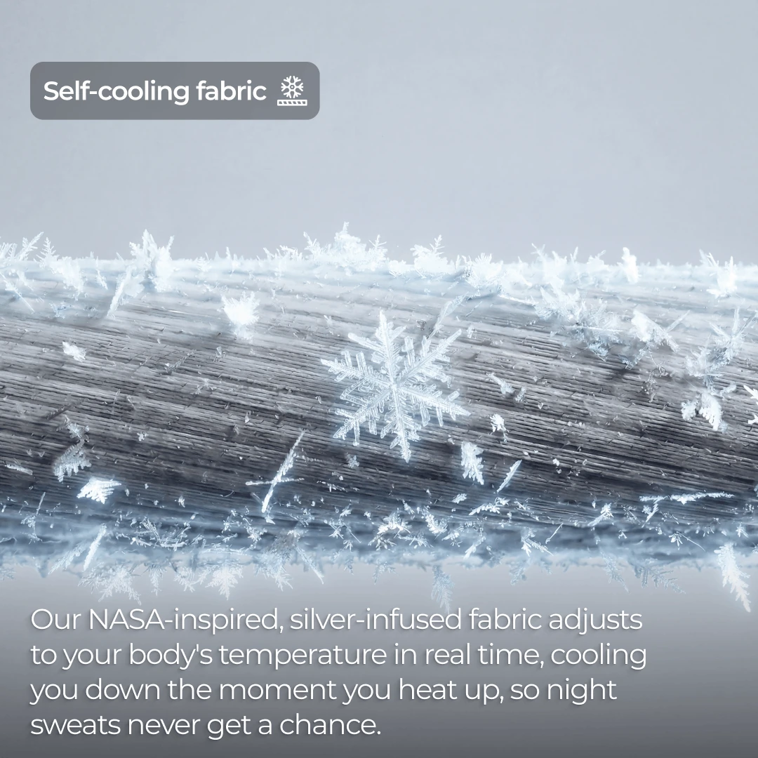 A close-up of a textured, grey fabric with snowflakes and ice crystals forming on top of it.