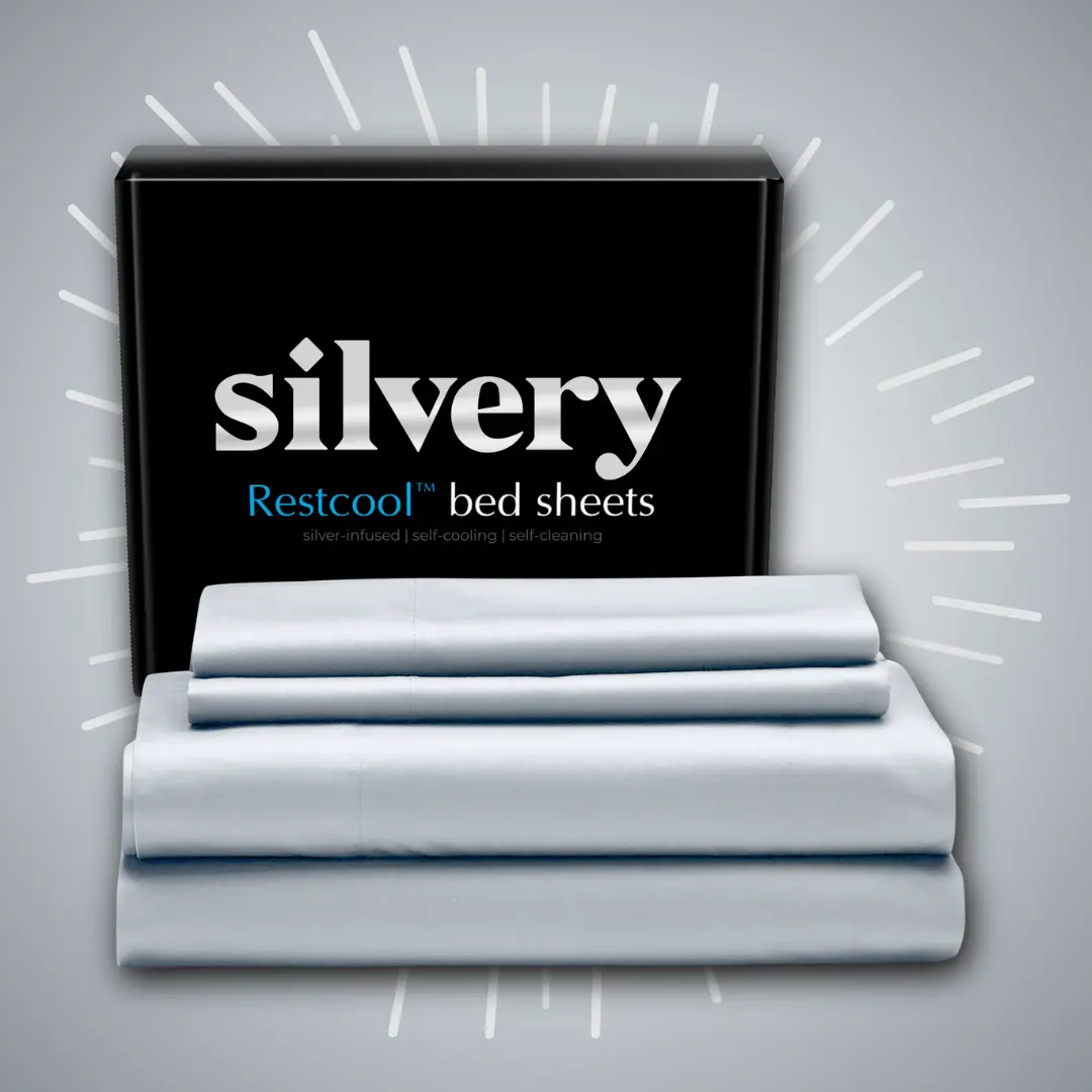 Stack of folded bed sheets with 'silvery' packaging in the background.