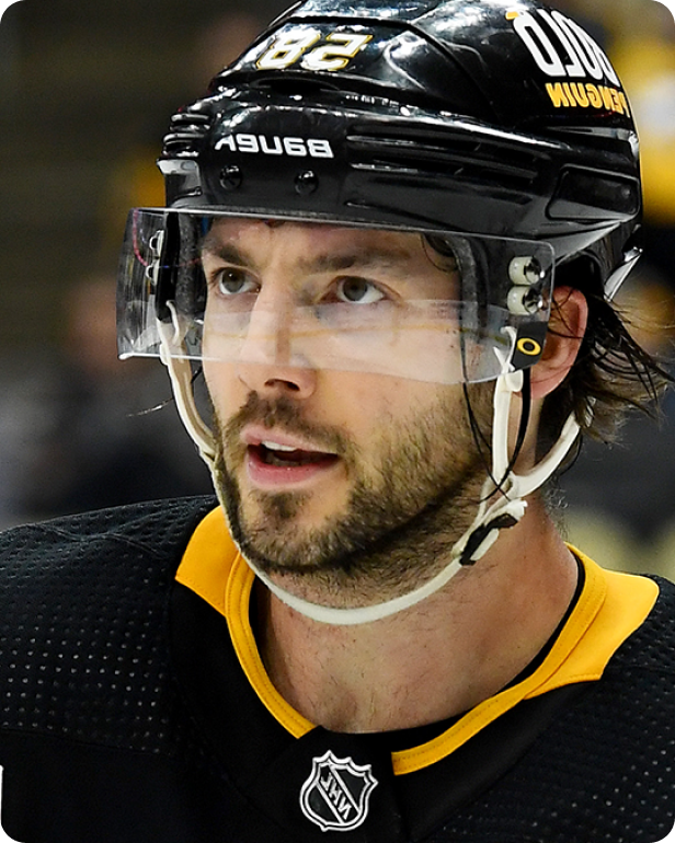 A close-up of a male ice hockey player wearing a black helmet and jersey with yellow accents.