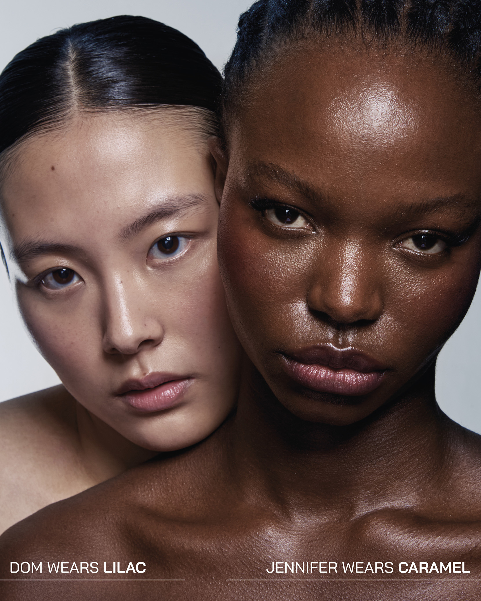 Two people with different skin tones, close together, against a plain background.