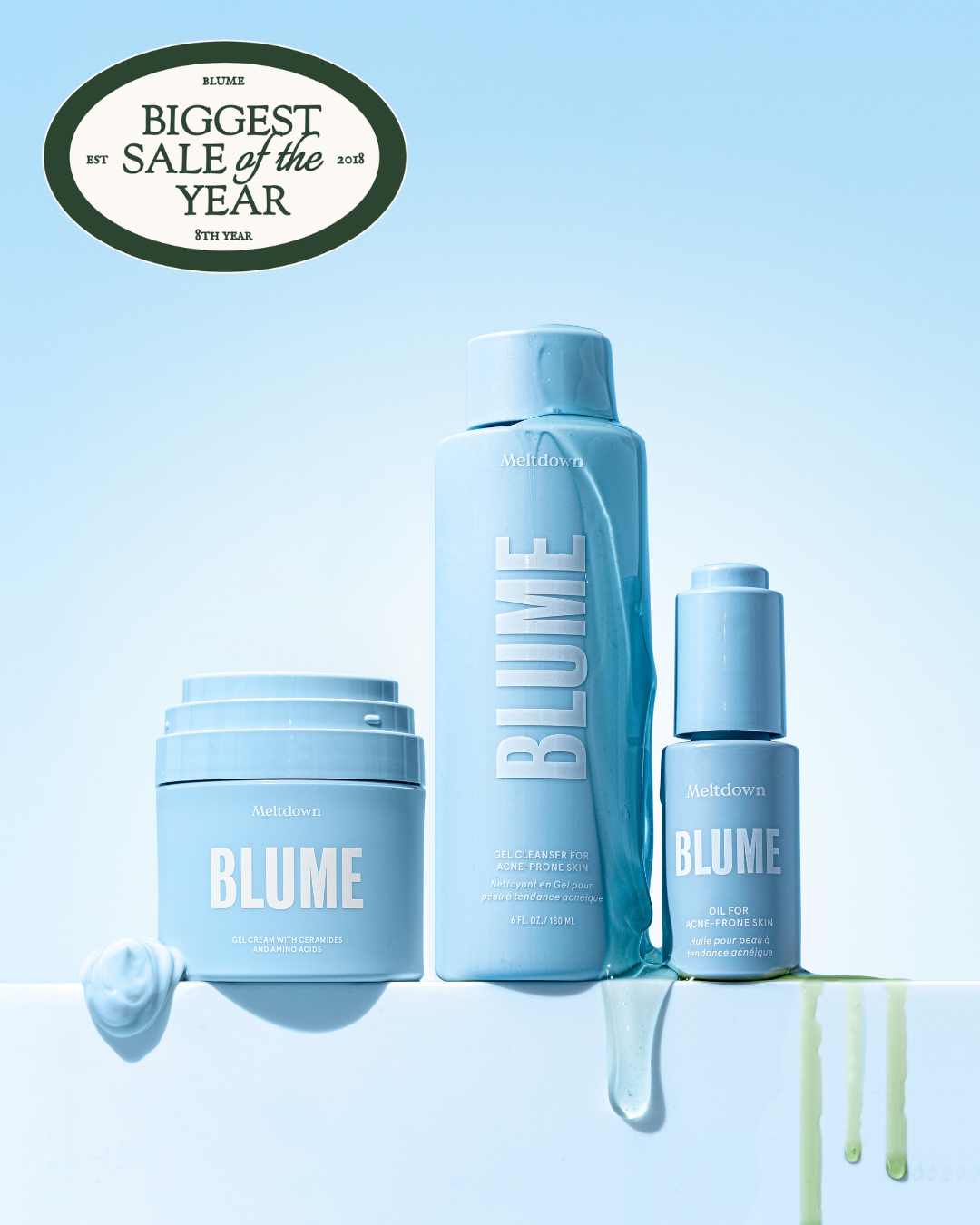 A set of three light blue Blume skincare products next to a matching blue and white patterned bag.