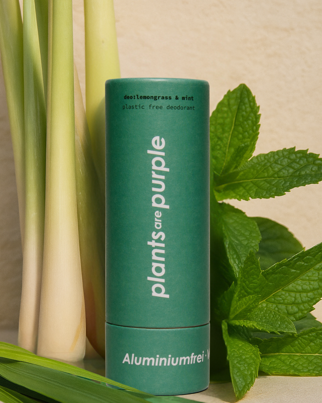 Green deodorant stick with lemongrass and mint leaves.