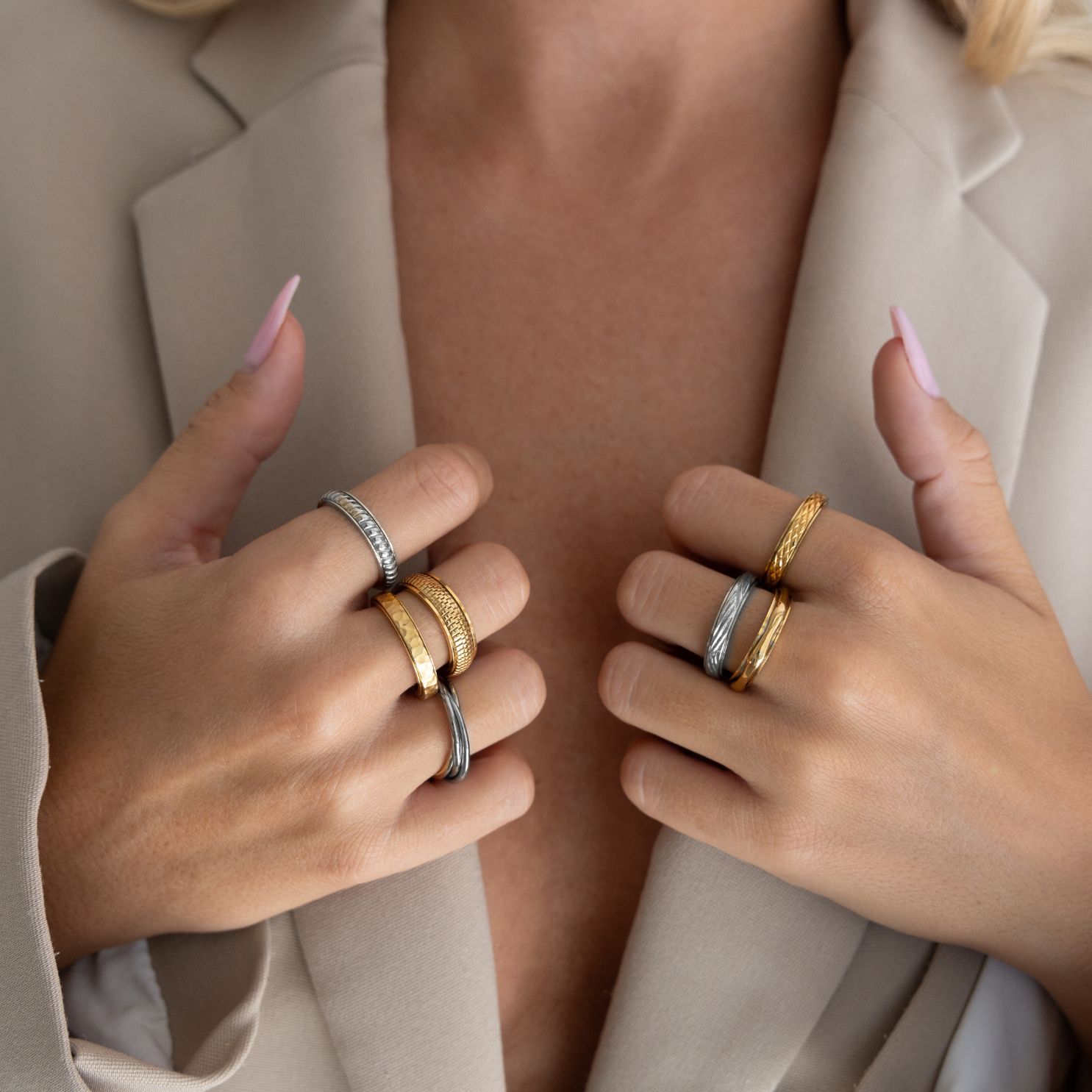 Close-up of hands with multiple gold and silver rings.