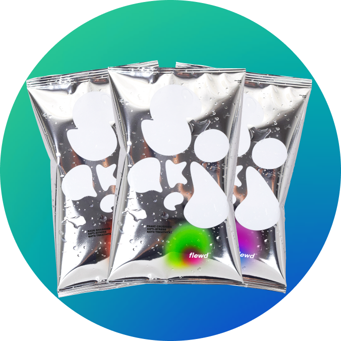 Three wet, silver foil pouches with abstract white designs against a green and blue circular background.