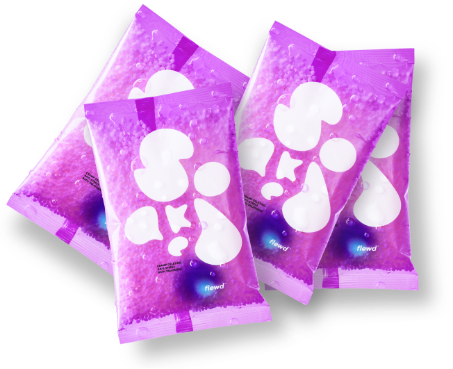 Four fanned out packets of purple Flewd bath beads, covered in water droplets.