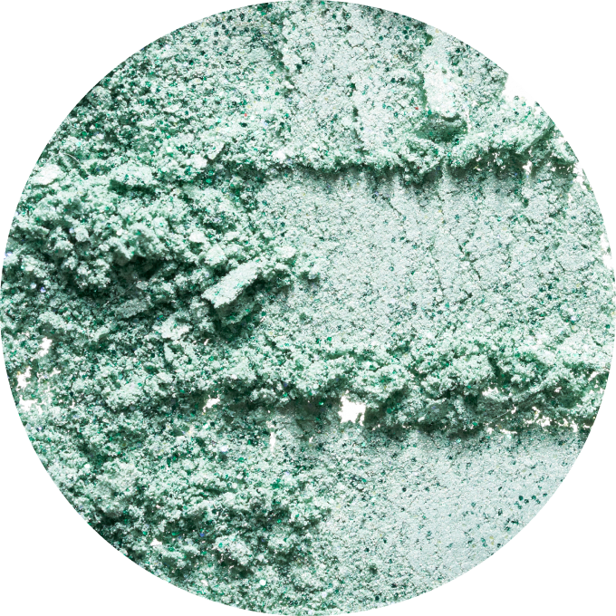 Close-up of textured green powder in a circular frame.