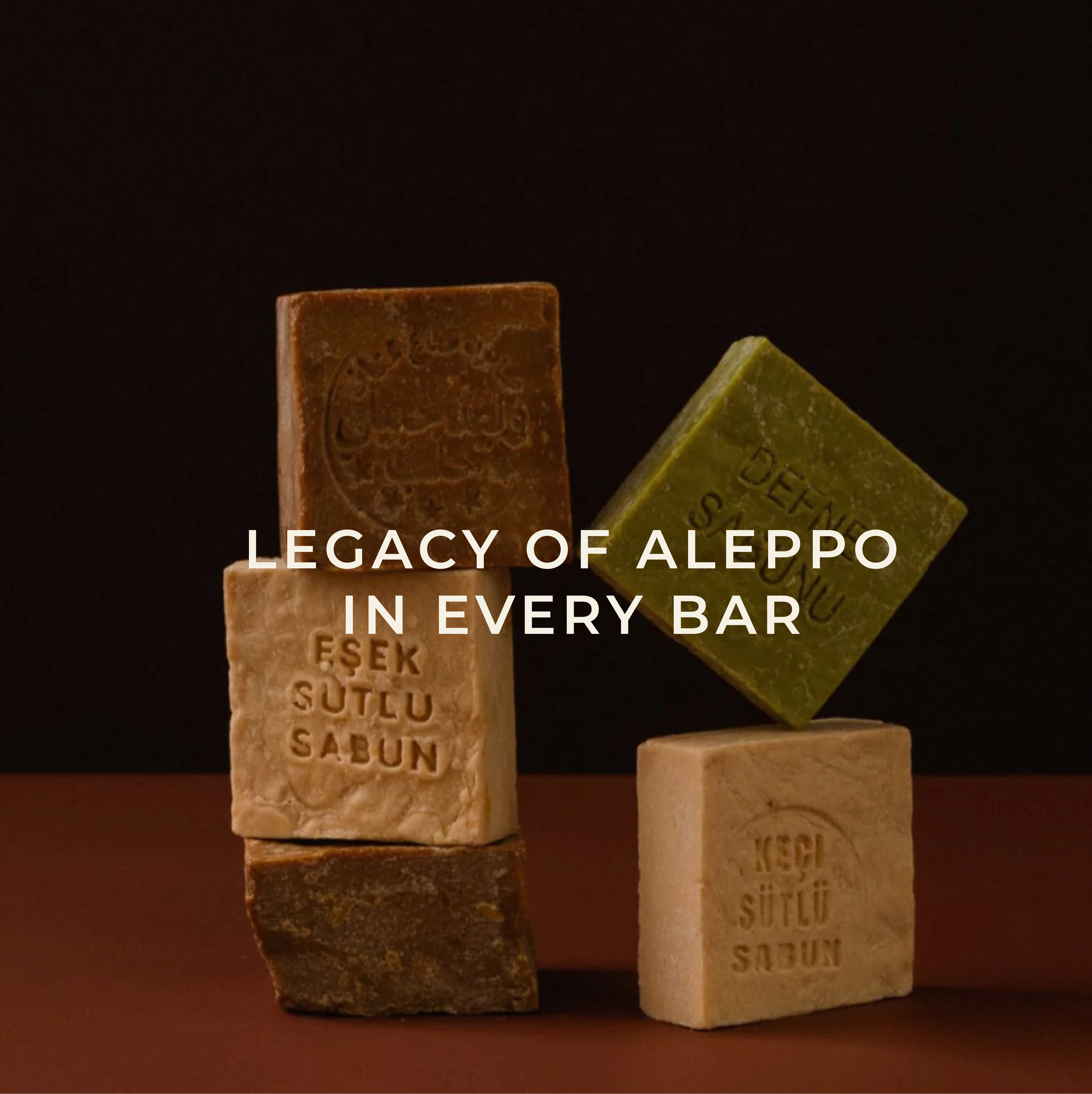 Stacked bars of soap with embossed text and 'Legacy of Aleppo' overlay.