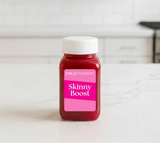 Small red juice bottle labeled 'Skinny Boost' on a kitchen counter.