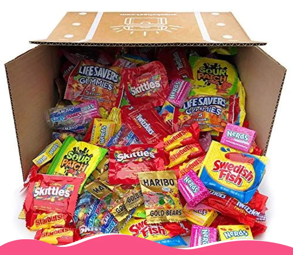 A cardboard box overflowing with a wide assortment of popular brand-name candies.