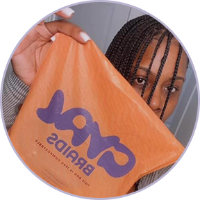 Person holding an orange bag with 'Oval Braids' text.