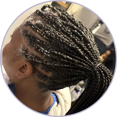 Person with braided hair tied into a ponytail.