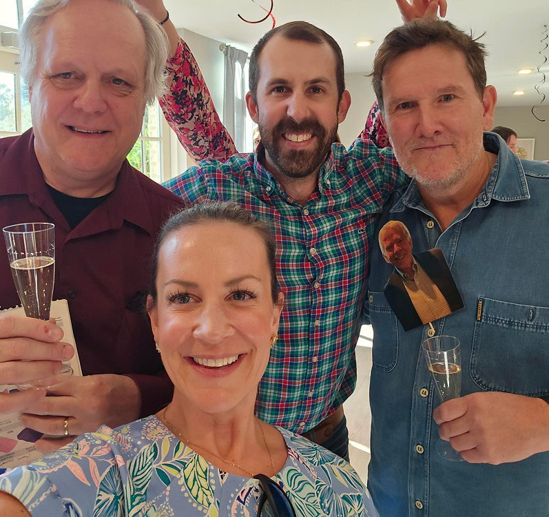 A group of people smiling and holding drinks.