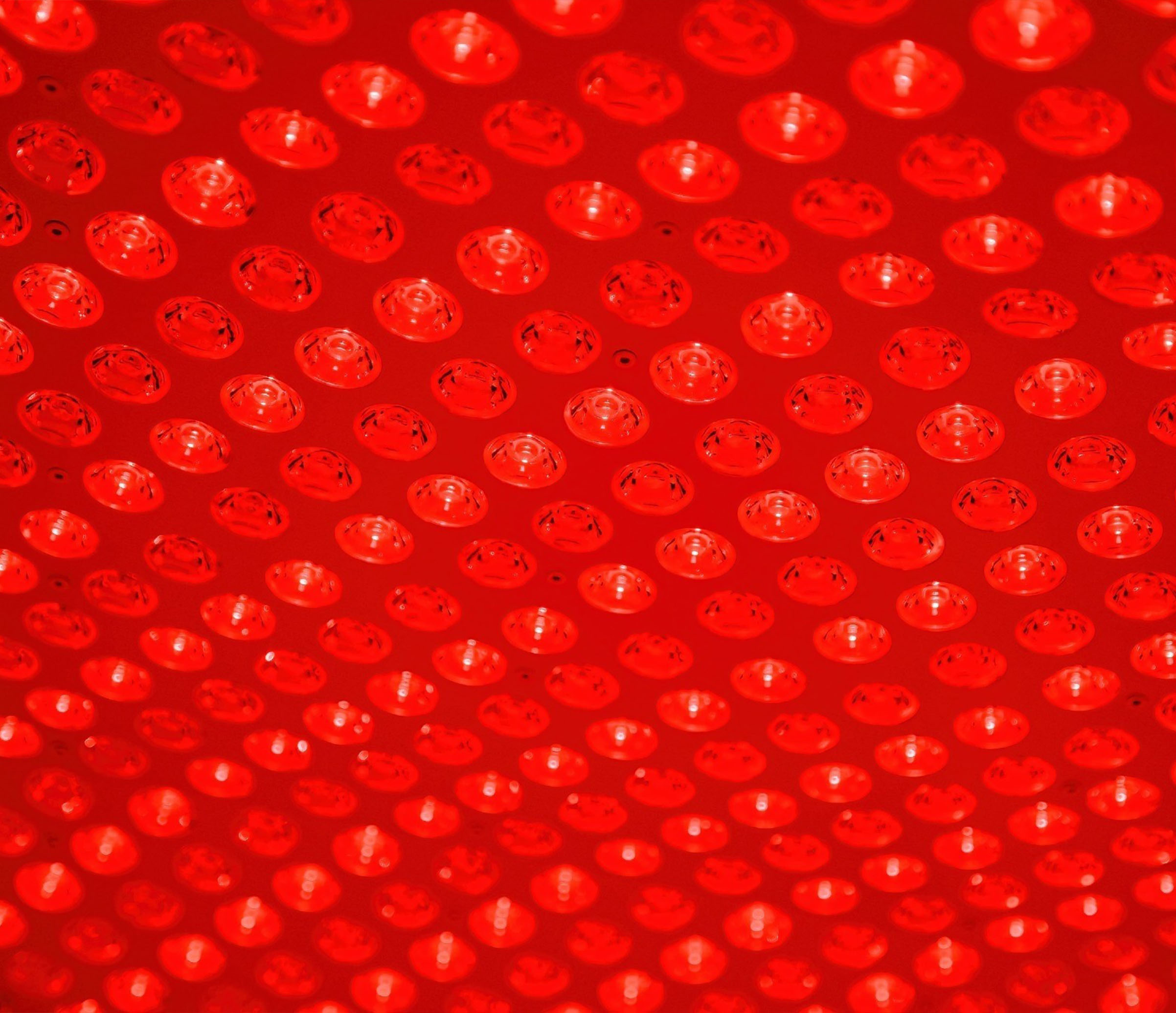 Close-up of a red LED light panel with circular patterns.