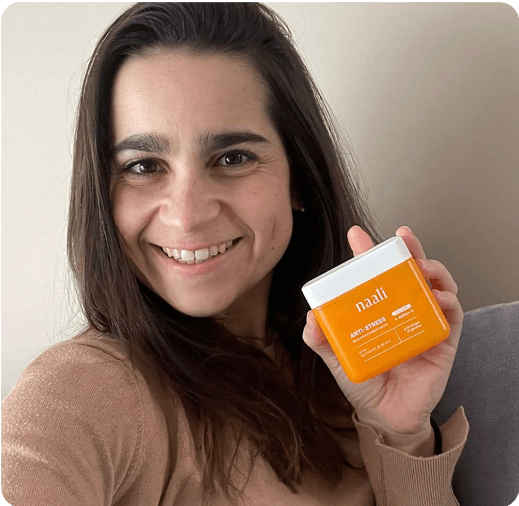 Person smiling, holding an orange container labeled 'naali'.