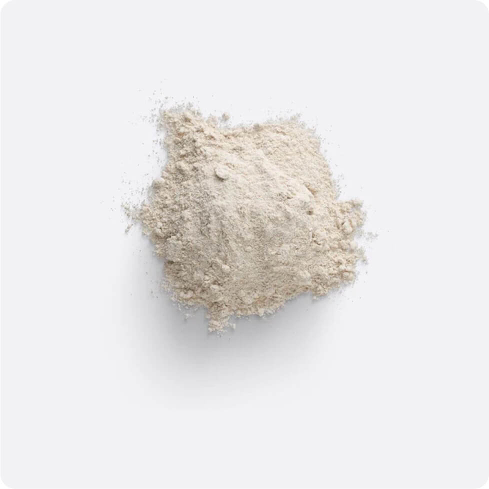 Pile of beige powder against a plain background.