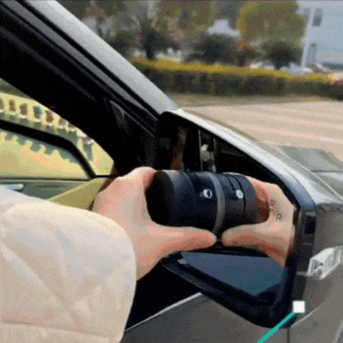 Person holding a detachable car side mirror with a camera.