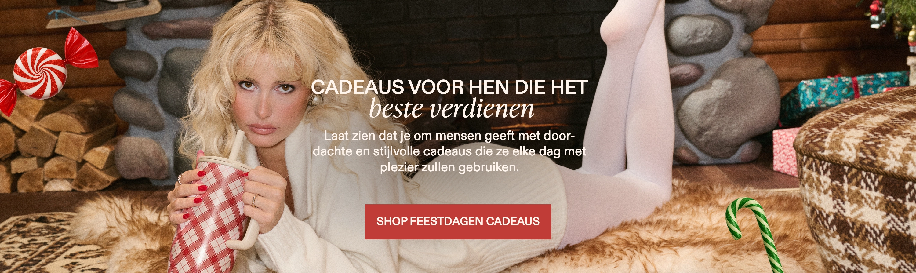 Person lounging with a mug in a cozy room with gifts and holiday decorations.