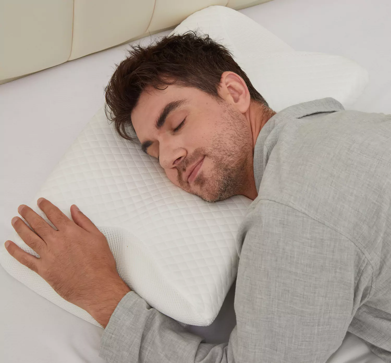 Man sleeping on a white pillow with a content expression.