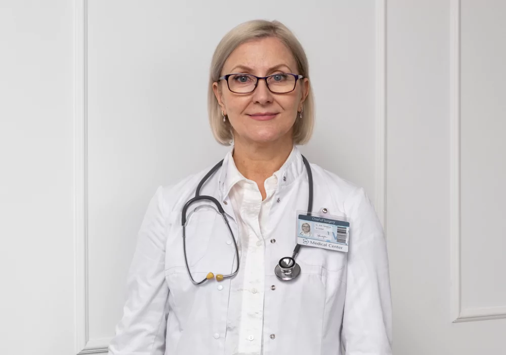 A doctor in a white coat with a stethoscope and ID badge.