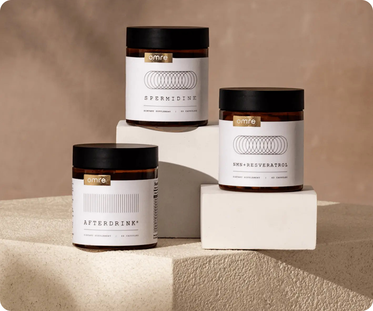 Three jars of dietary supplements on textured blocks.