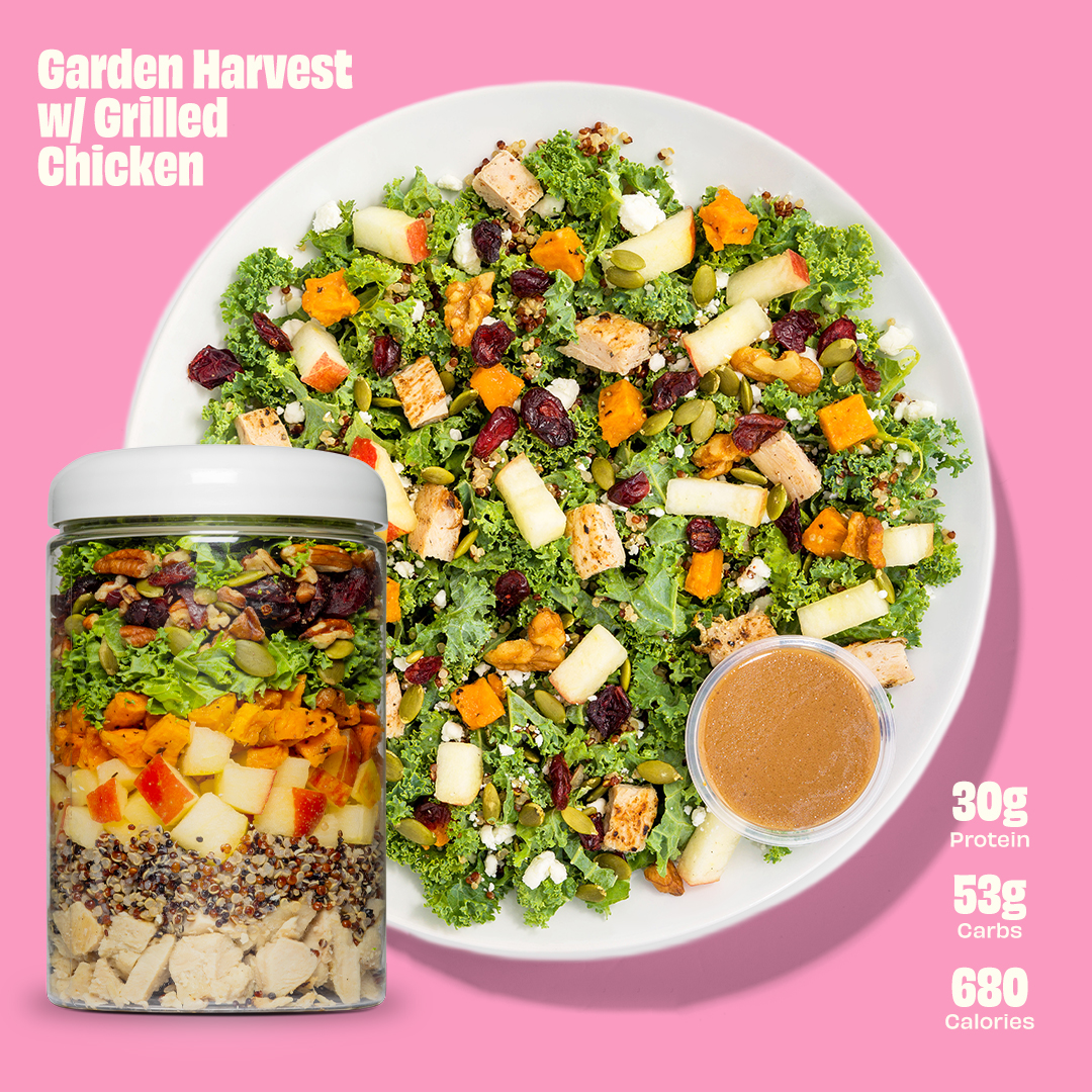 Salad with grilled chicken, vegetables, and dressing on a pink background. Nutrition info included.