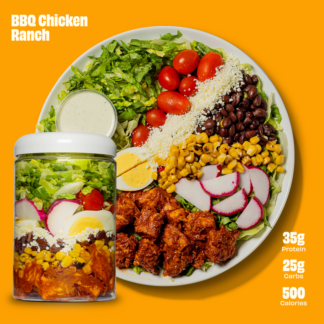 A monstera leaf in a clear glass vase against a white background.