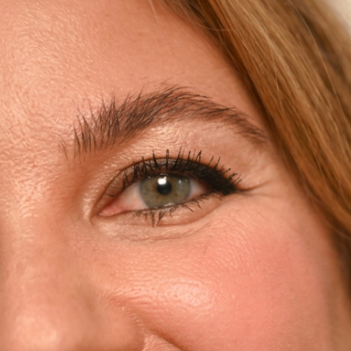 Close-up of a mature woman's eye with long, defined, flake-free lashes wearing tubing mascara