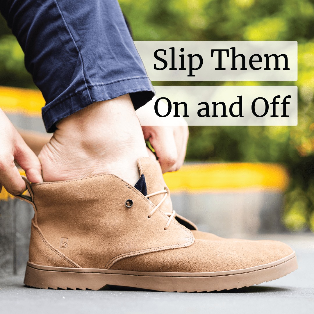 Person slipping on a tan suede shoe with text 'Slip Them On and Off'.