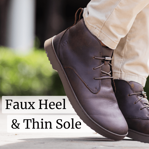 Close-up of brown leather shoes with faux heel and thin sole, worn with beige pants.