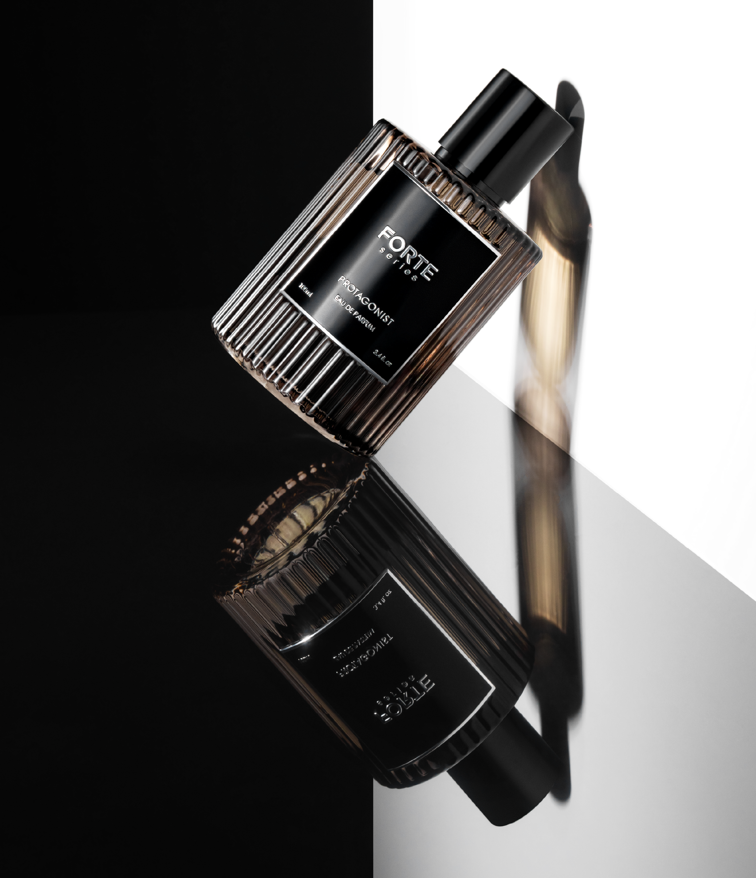 Perfume bottle with black label and reflection on a glossy surface.