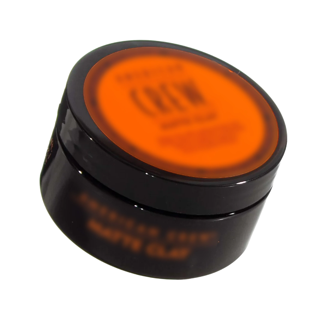 Black and orange jar with lid, possibly for hair or skincare product.