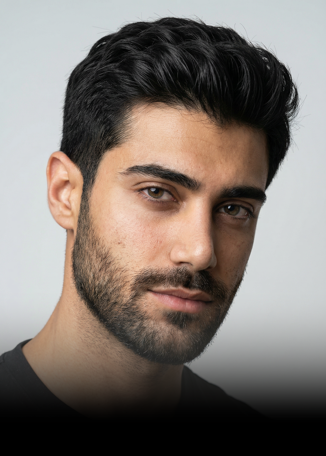 A headshot of a man with dark hair and a short beard, looking at the camera.