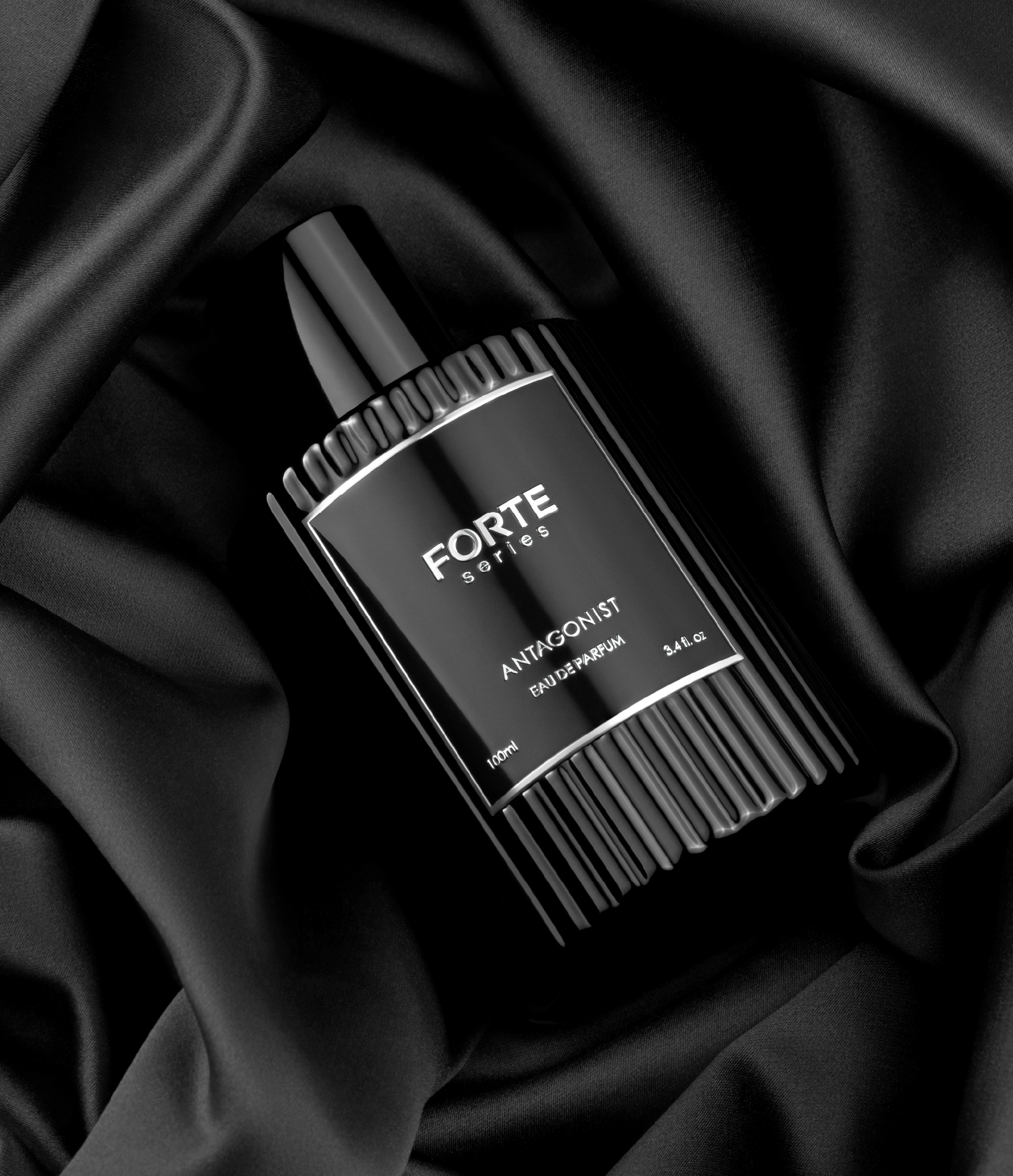 Black perfume bottle on black satin fabric.