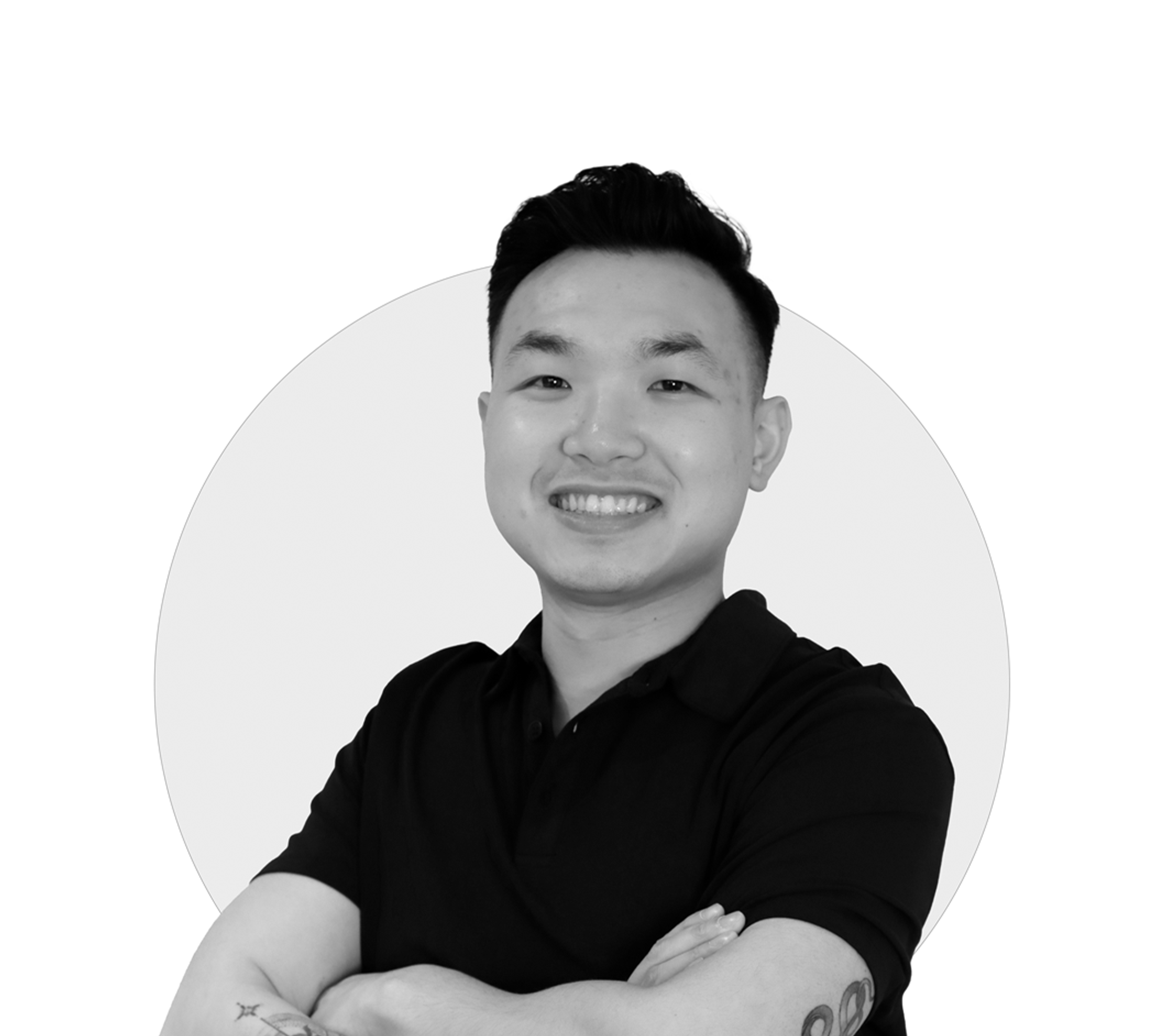 Smiling person with crossed arms in a black shirt, monochrome image.
