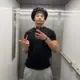 Person taking a mirror selfie in an elevator, wearing a black shirt and light pants.