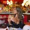 Person sitting in a vibrant bar holding a drink.