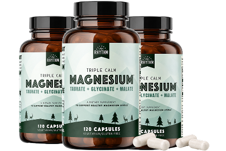 Three bottles of Rhythm brand Triple Calm Magnesium supplement with several white capsules in front.