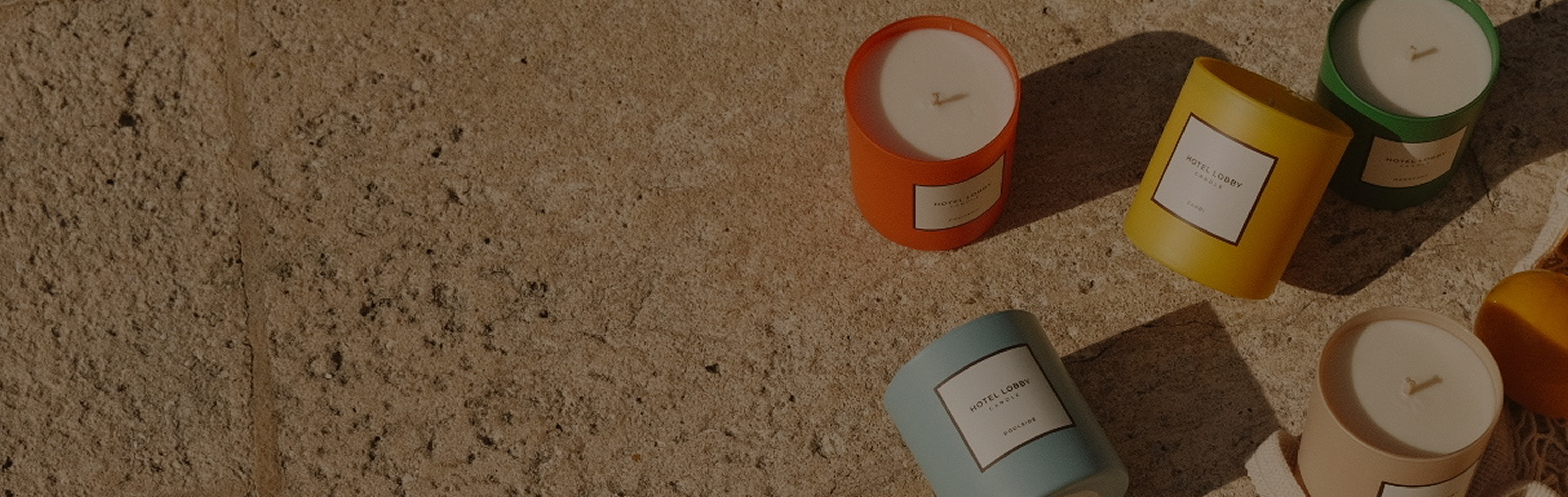Colorful candles on a textured stone surface.