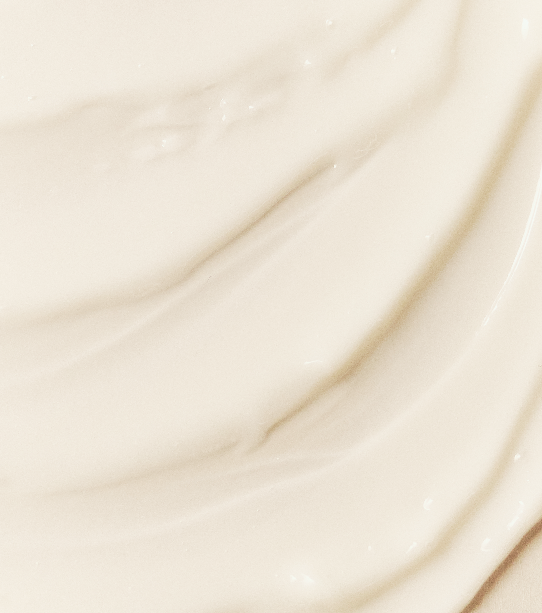 A close-up, abstract view of a thick, off-white cream with soft, wavy swirls.