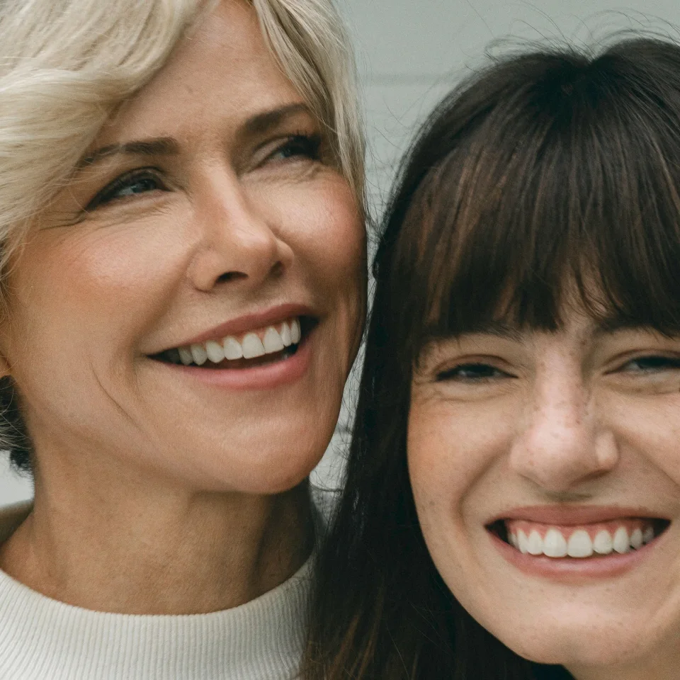 Two people smiling closely together, showing happiness and connection.