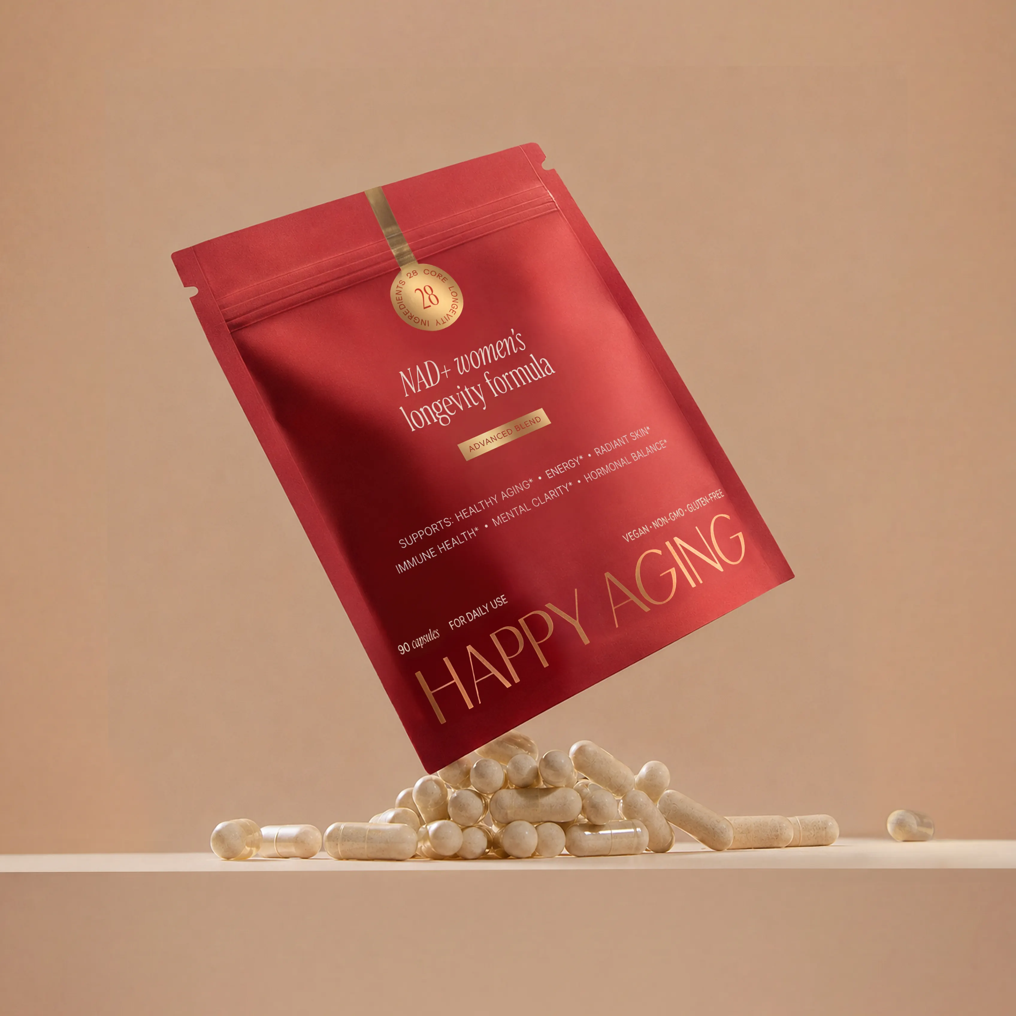 A red pouch of Happy Aging NAD+ supplements with capsules spilling out onto a beige surface.