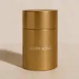 A gold-colored cylindrical container with a minimal design on a plain background.