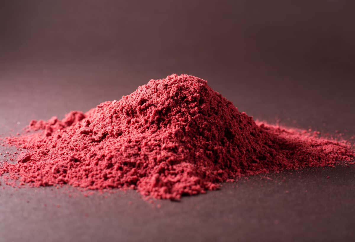 A pile of red powder on a dark surface.