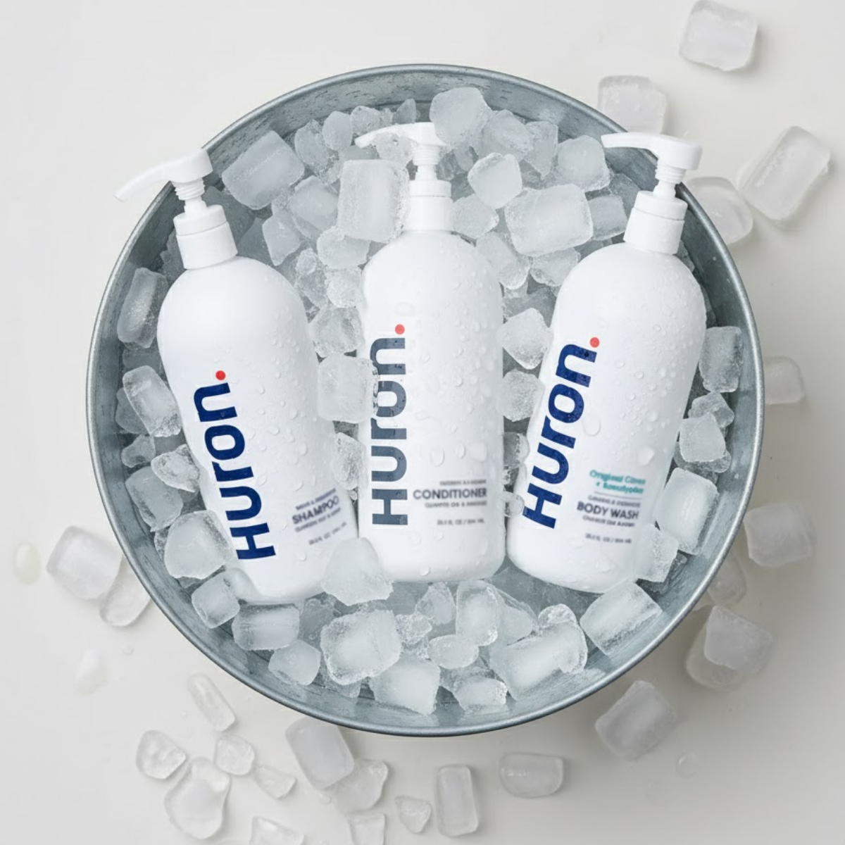 Three Huron bottles in a tub of ice cubes.